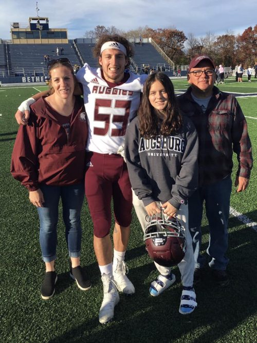 Four people standing on a football field